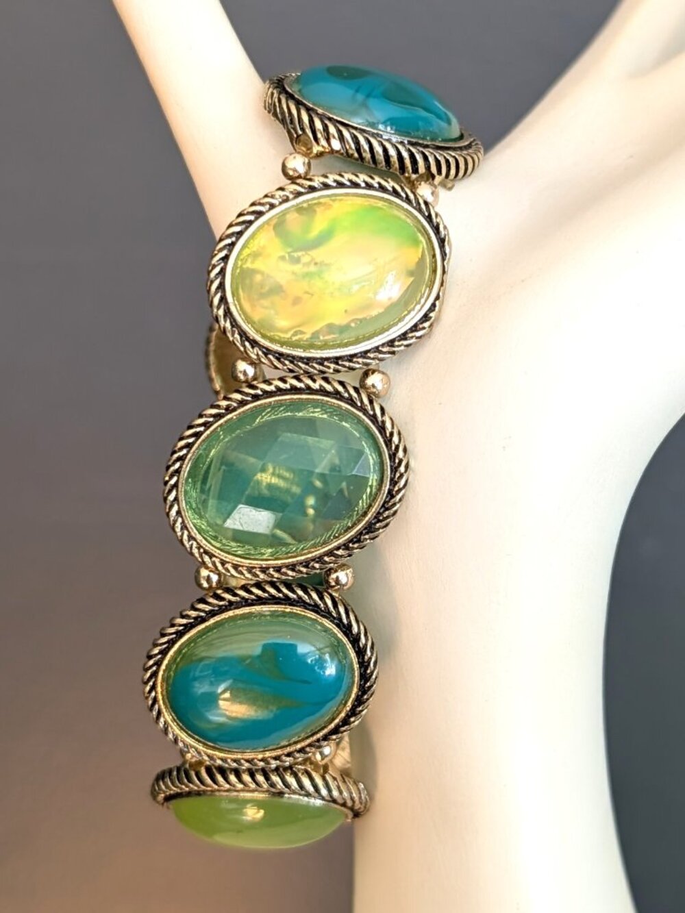 Green, teal and yellow beaded gold tone stretch bracelet